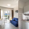Cucina e soggiorno con divano blu, tavolo apparecchiato e accesso al giardino.